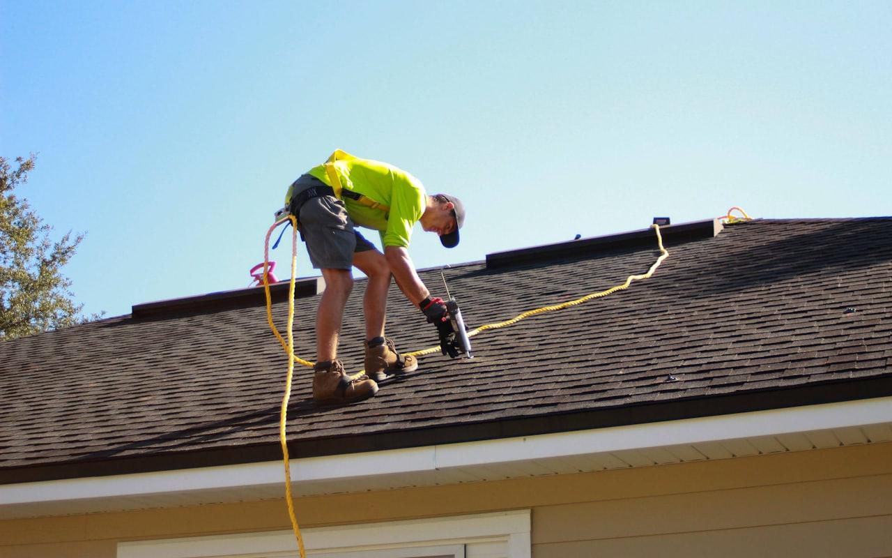 Professional roofer installing asphalt shingles on a residential roof