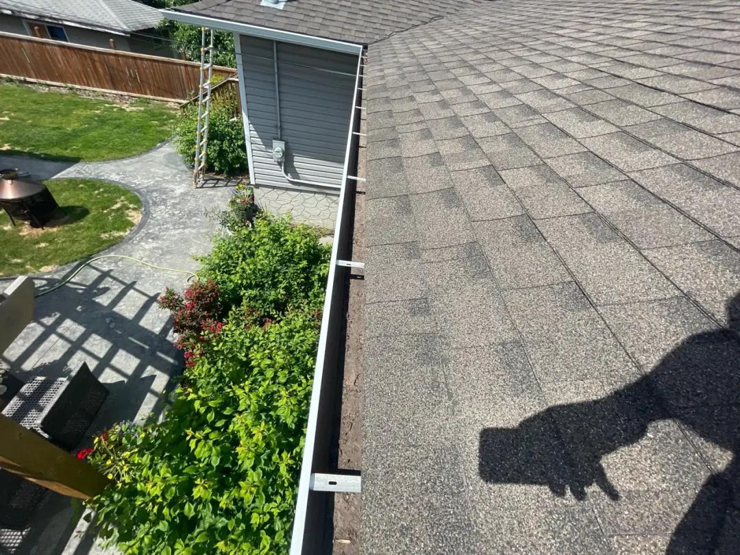 Inspecting the roof while clearing the gutters