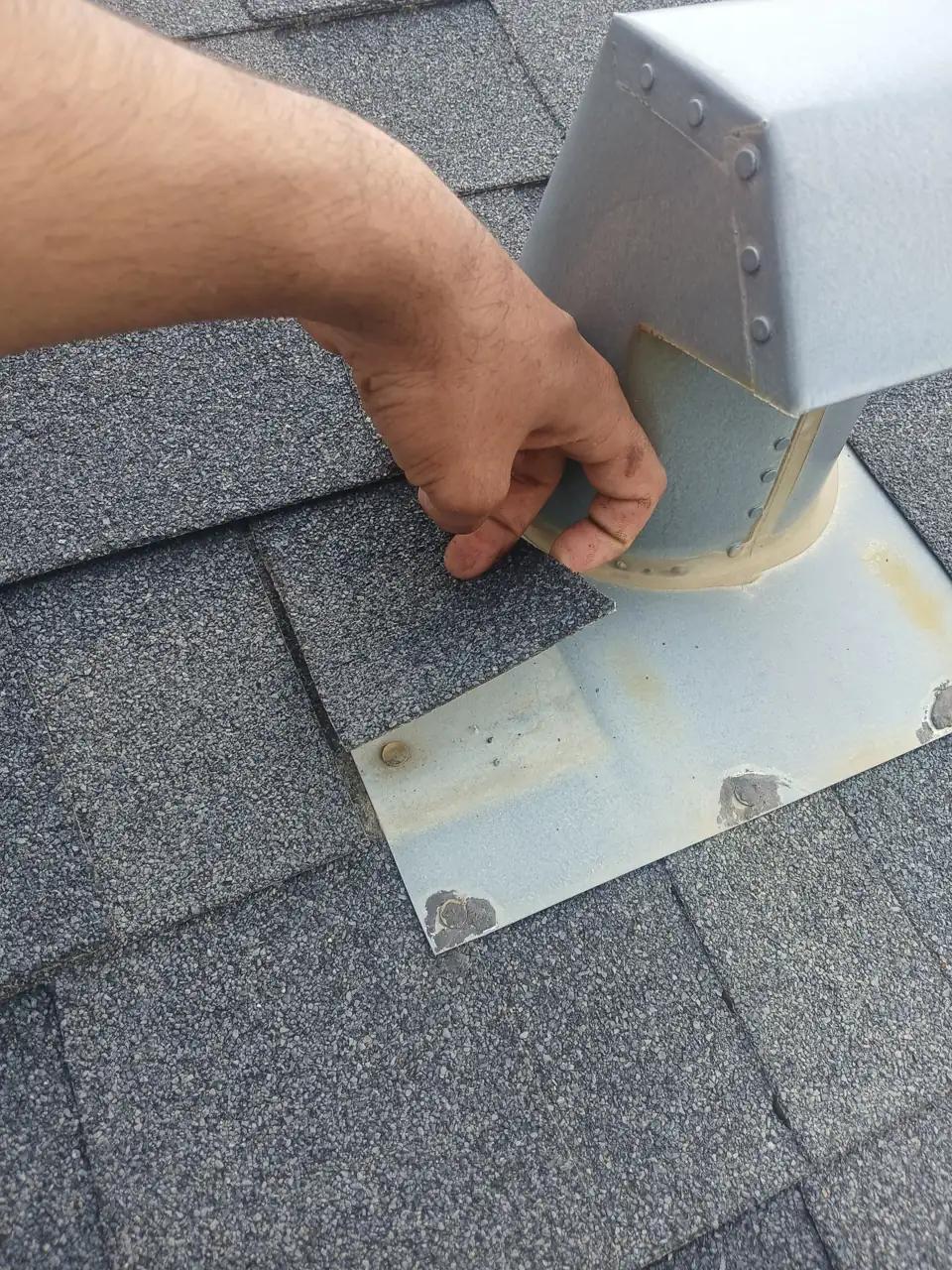 Roofer inspecting and sealing a shingle roof on an Edmonton home
